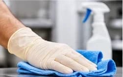 Disposable glove wiping a surface with a cloth