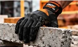 Gloved hand lifting a concrete block