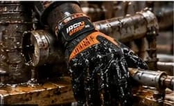 Gloved hand on oily pipework in a plant room